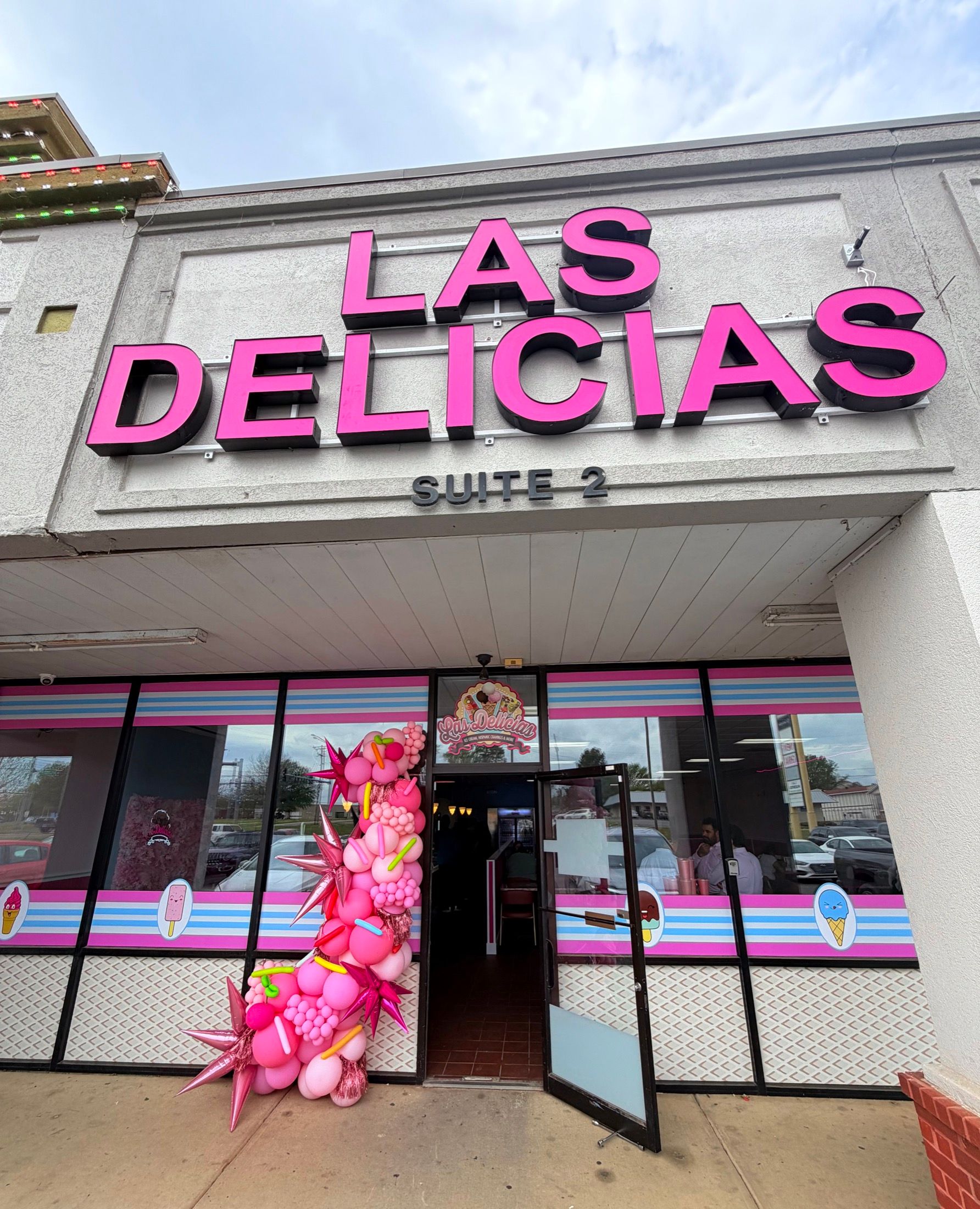 Las Delicias Russellville storefront with pink sign, striped windows, and balloon decor